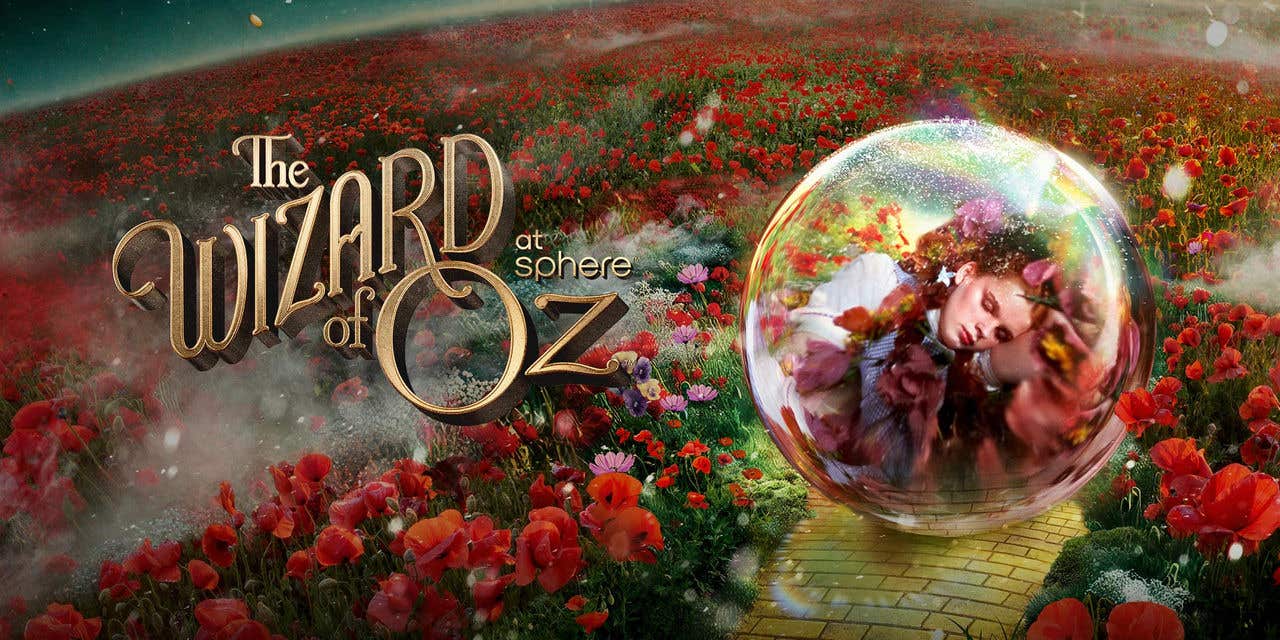 A vast field with red flowers and a yellow brick road with an transparent orb containing a visual of a girl in it, with the text The Wizard of Oz at Sphere to the left