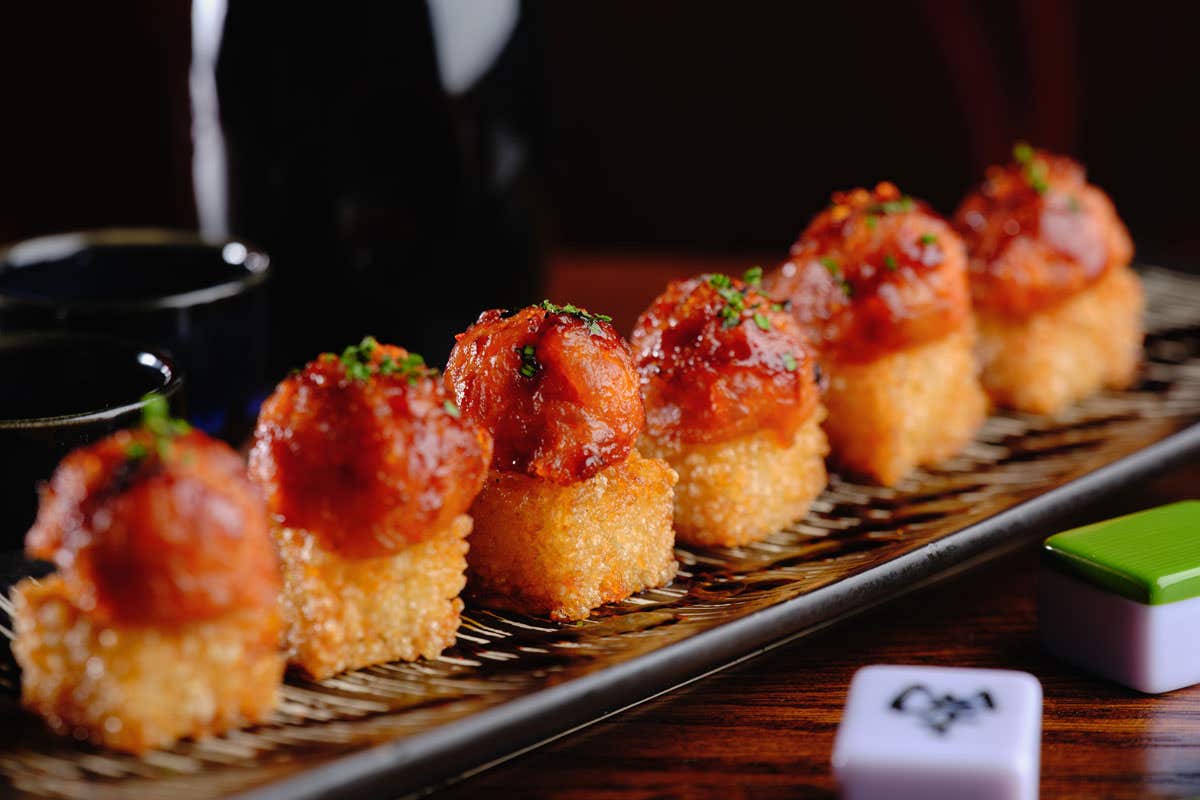 A long plate with squares of crispy rice topped with tuna
