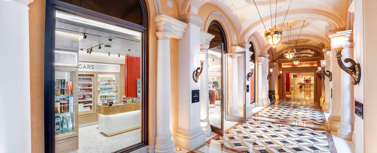 A hallway extending to the right with a storefront on the left with its doors open and large windows.